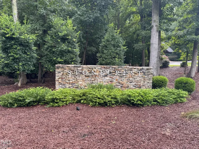 a sign that is sitting in front of a tree