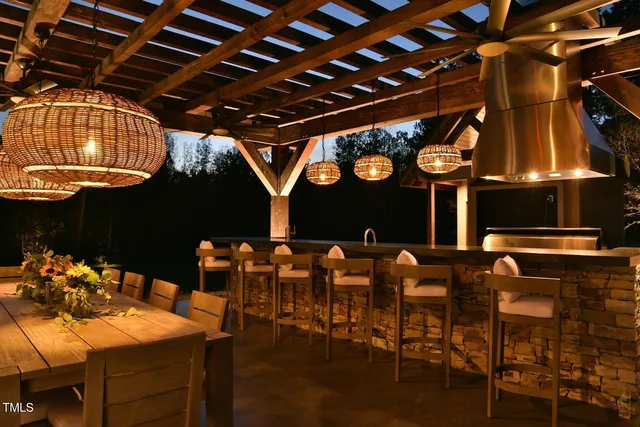 a view of a white house next to a yard with big trees