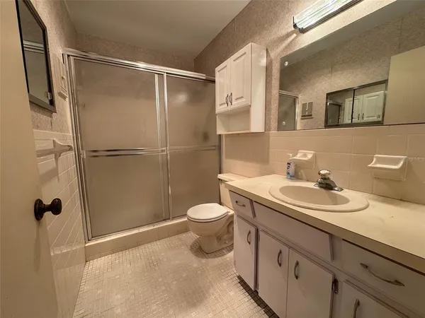 a bathroom with a granite countertop sink toilet and shower