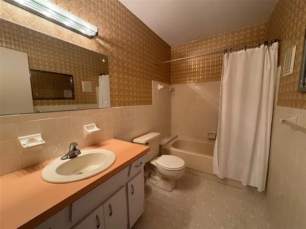 a bathroom with a sink toilet a mirror and shower