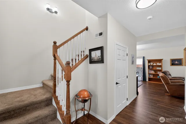 a view of a hallway with wooden floor and stairs