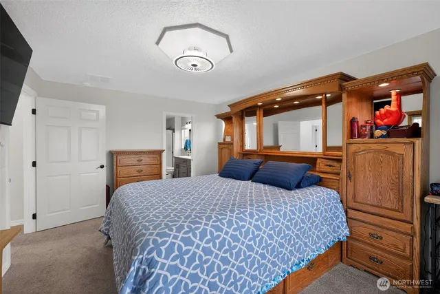 a bedroom with a bed and dresser with mirror