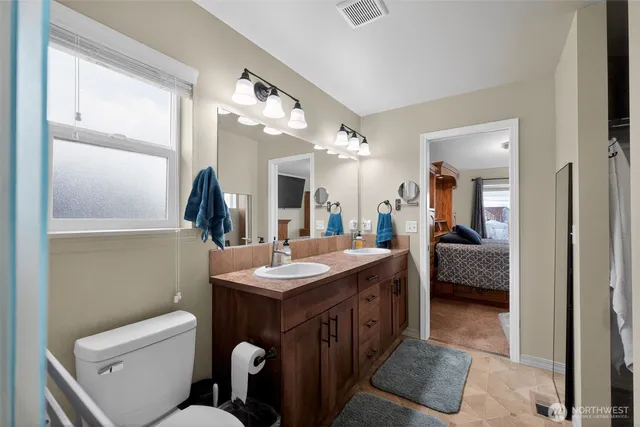 a bathroom with a toilet a sink and mirror