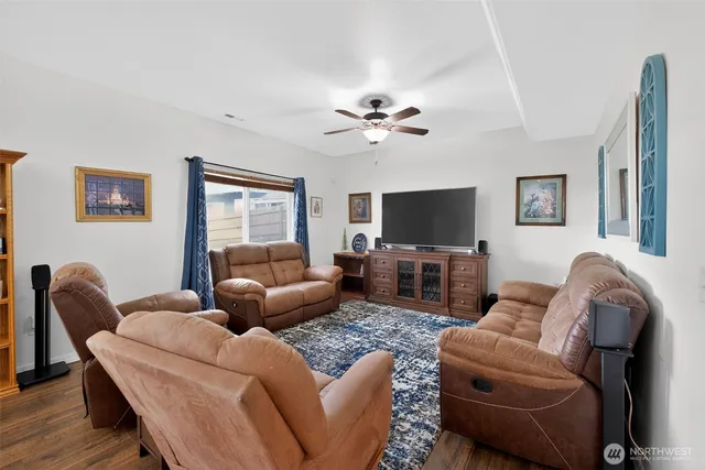 a living room with furniture a flat screen tv and a window