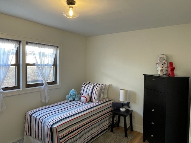 446 East 90th Street Chicago, IL 60619 - Photo 19 of 36 a bedroom with a bed and wooden floor