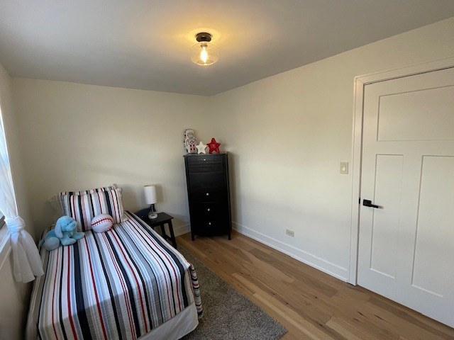 446 East 90th Street Chicago, IL 60619 - Photo 20 of 36 a bedroom with a bed and wooden floor