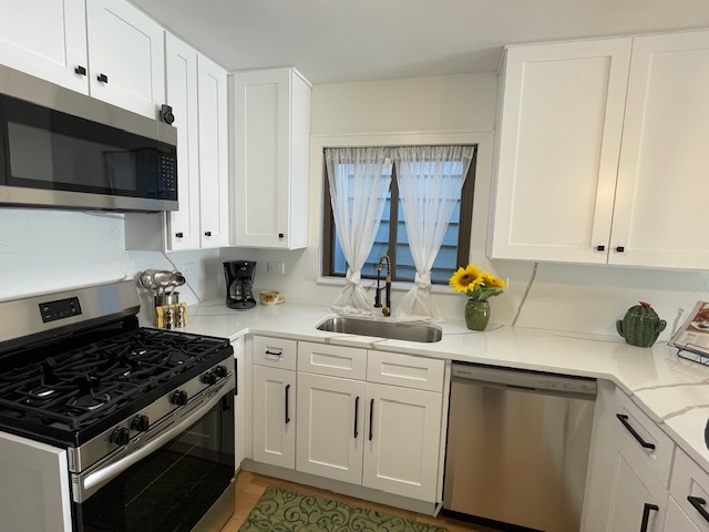 446 East 90th Street Chicago, IL 60619 - Photo 10 of 36 a kitchen with white cabinets and appliances