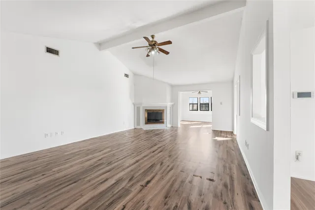 a view of a livingroom with wooden floor and a ceiling fan