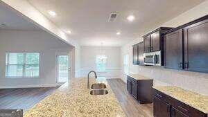 233 Carsons Walk Macon, GA 31206 - Photo 8 of 15 a kitchen with granite countertop a stove a sink and a microwave