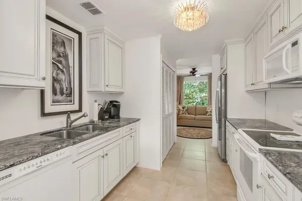 a large kitchen with granite countertop a sink and a stove top oven