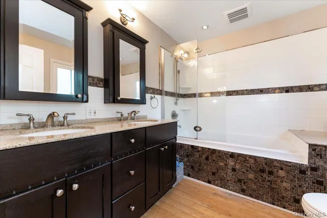 a bathroom with a sink vanity granite and a mirror