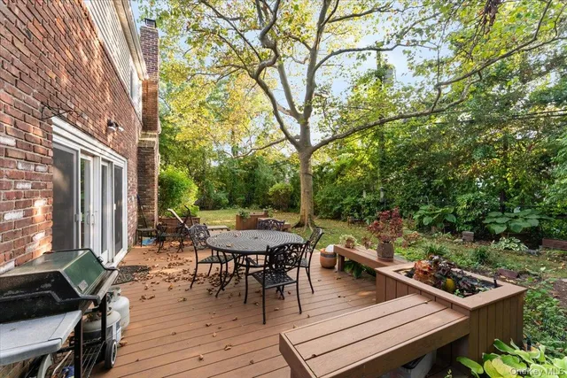 a view of a roof deck with table and chairs and wooden floor
