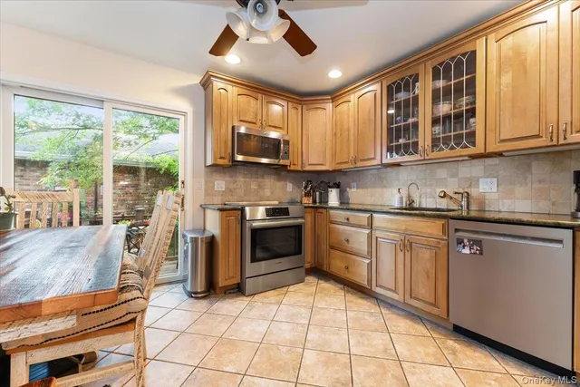 a kitchen with stainless steel appliances granite countertop a stove top oven a sink a counter space and cabinets