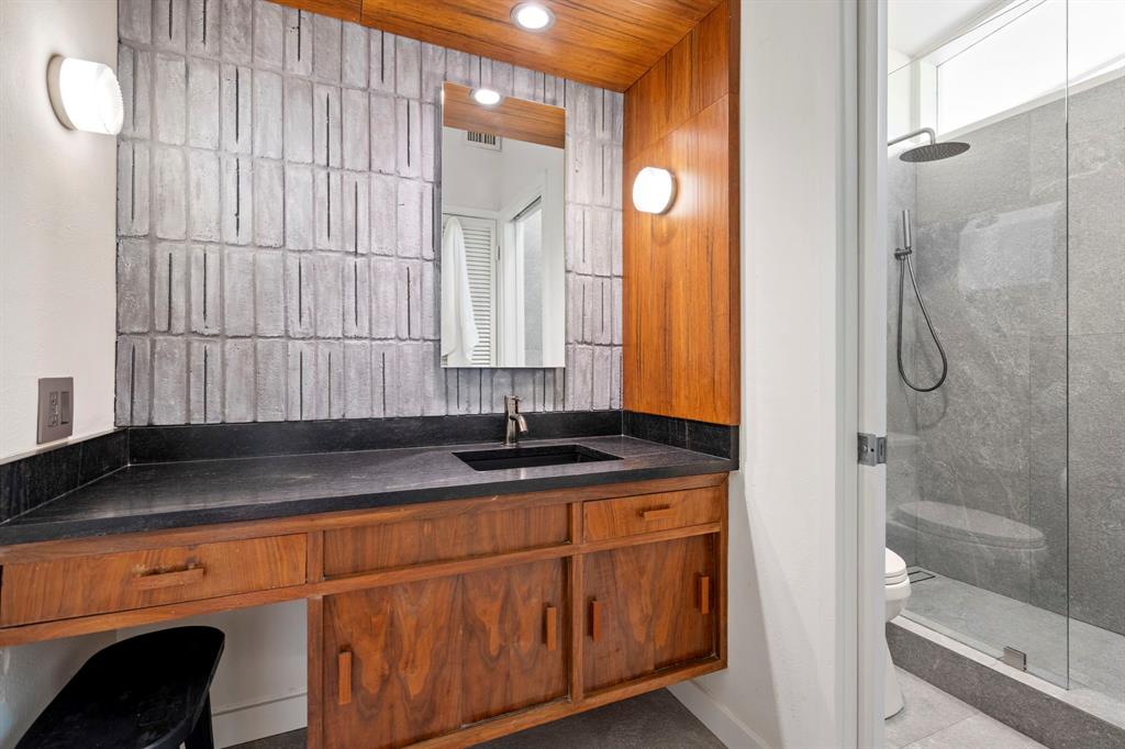 7320 Walling Lane Dallas, TX 75231 - Photo 22 of 40 a bathroom with a granite countertop sink a mirror and a shower