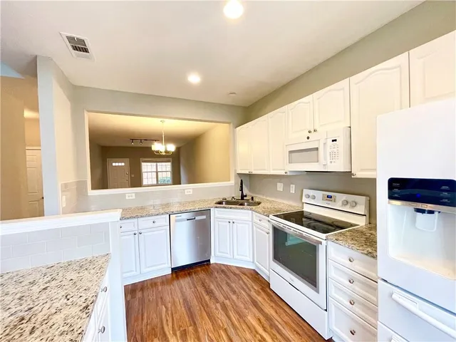 a kitchen with stainless steel appliances granite countertop a stove a sink and a refrigerator