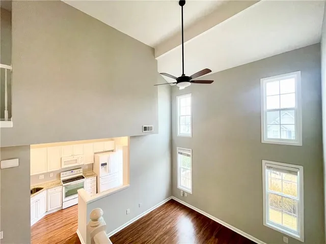 a view of an empty room with a window and wooden floor