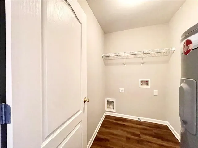 a view of a hallway with wooden floor and a bathroom