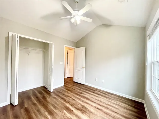 a view of a livingroom with wooden floor and a ceiling fan