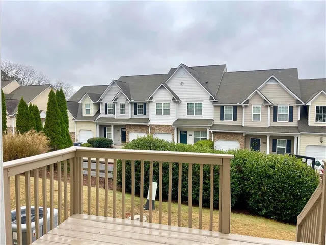 a view of a brick house with a small yard and plants
