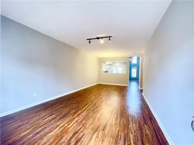 a view of empty room with wooden floor