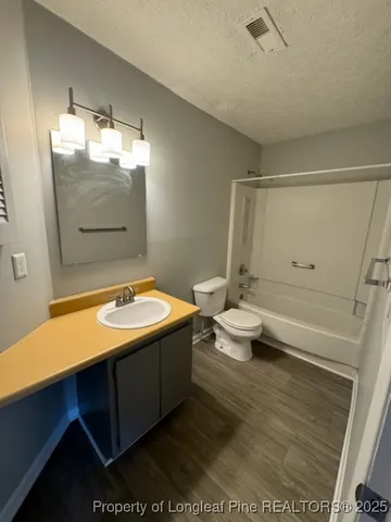 a view of an empty room with a chandelier fan