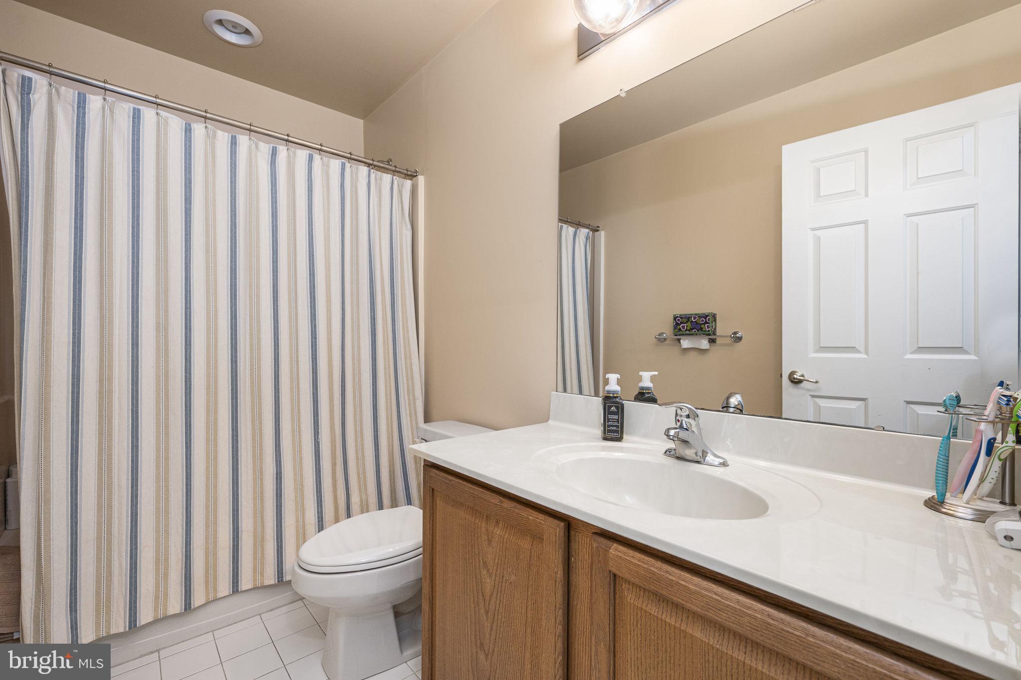 24 Longview Lane Newtown Square, PA 19073 - Photo 21 of 32 a bathroom with a sink a toilet and shower curtain
