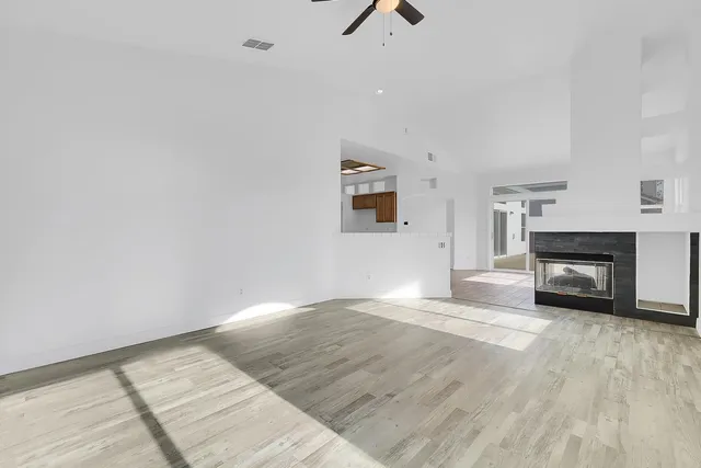 a view of an empty room with a fireplace and a window