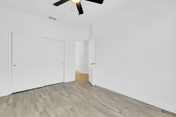 a view of an empty room with wooden floor