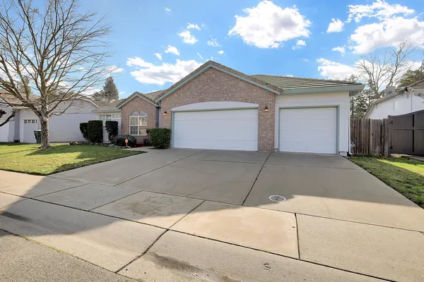a view of a house with a yard and large tree