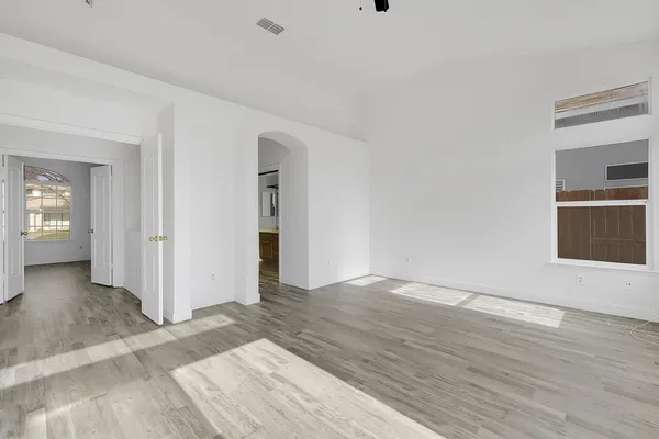 a view of an empty room with closet and a window