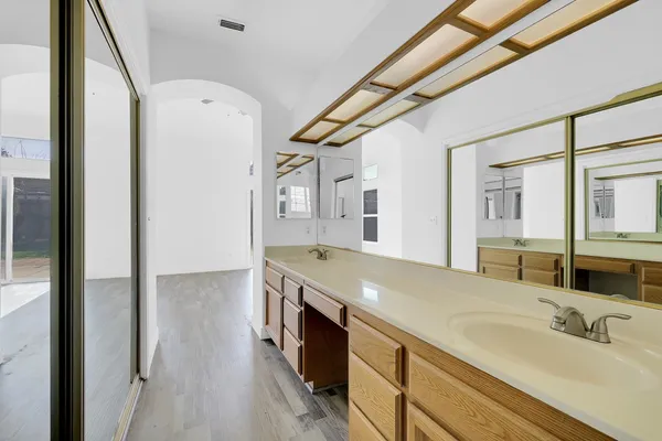 a spacious bathroom with a granite countertop sink a mirror and shower