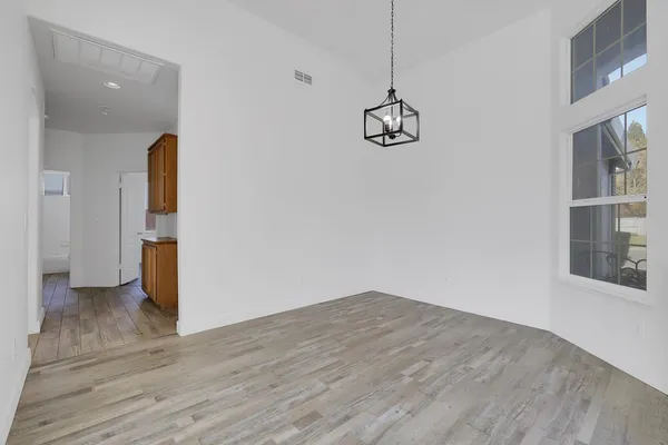 a view of a room with wooden floor and ceiling fan