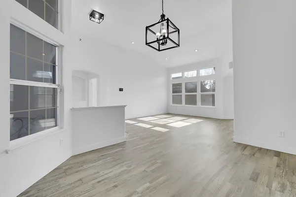 a view of empty room with windows and wooden floor