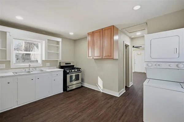 a kitchen with granite countertop white cabinets and wooden floor
