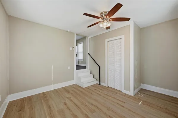 a view of a livingroom with wooden floor and a ceiling fan