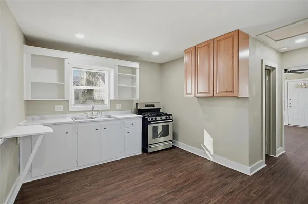 a kitchen with granite countertop wooden floors and white stainless steel appliances