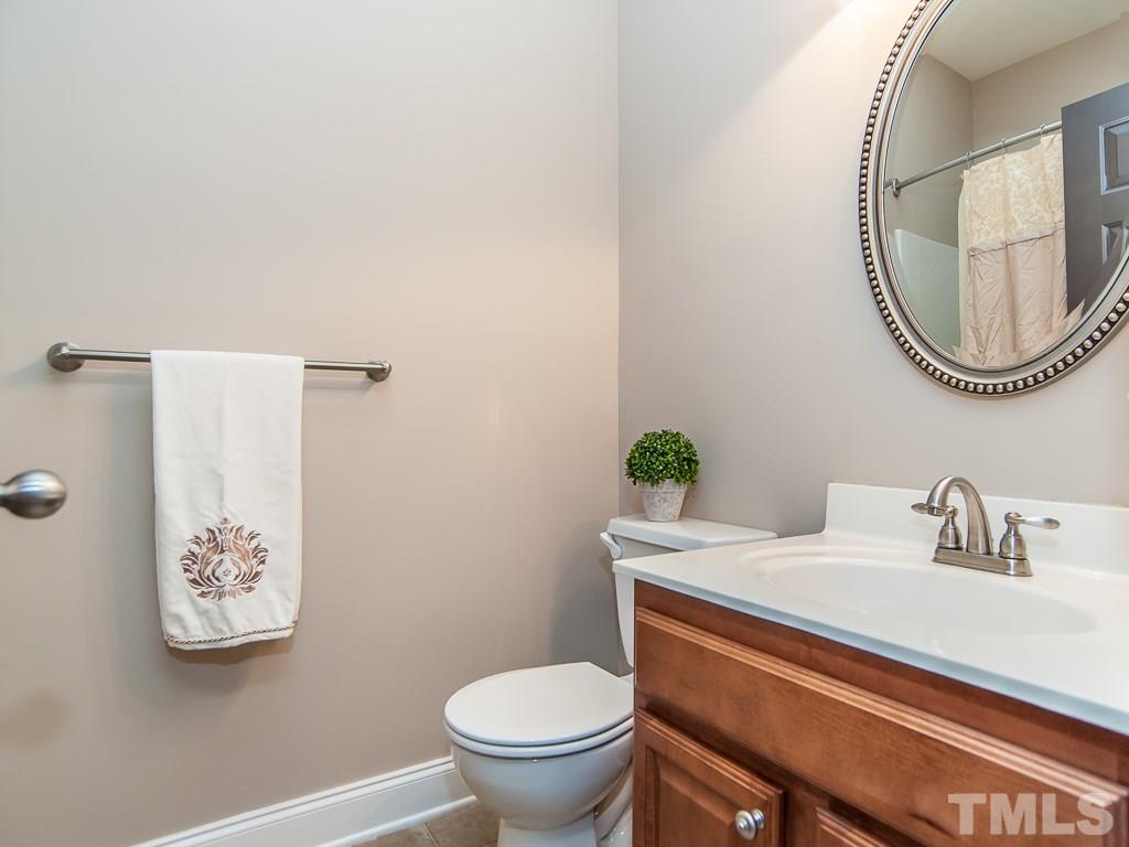 6040 Ricker Road Raleigh, NC 27610 - Photo 14 of 25 a bathroom with a toilet a sink and mirror
