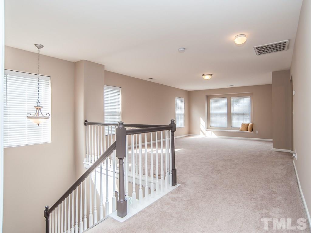 6040 Ricker Road Raleigh, NC 27610 - Photo 15 of 25 a view of a hallway with wooden floor and windows