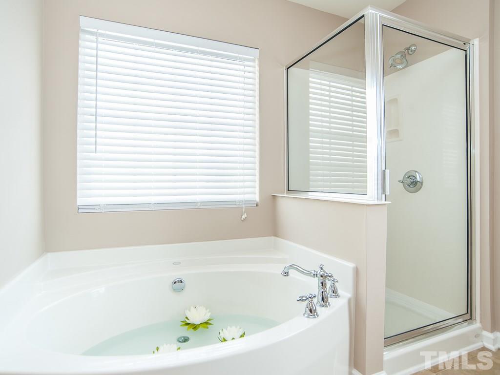 6040 Ricker Road Raleigh, NC 27610 - Photo 21 of 25 a white bath tub sitting next to a window