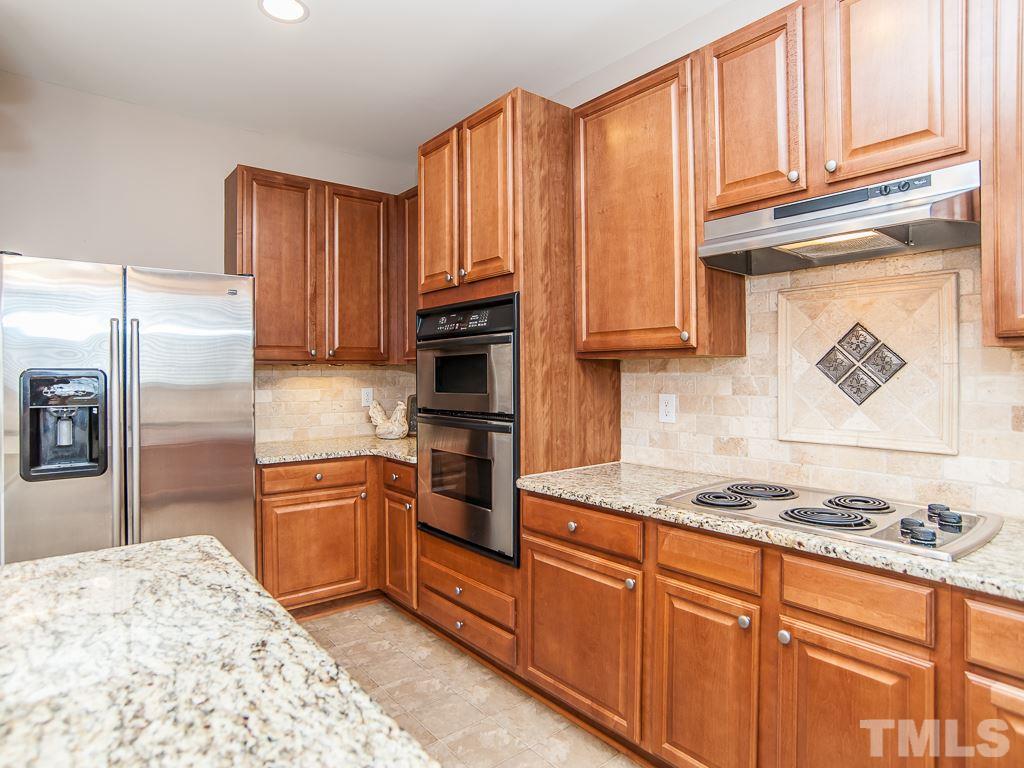 6040 Ricker Road Raleigh, NC 27610 - Photo 4 of 25 a kitchen with stainless steel appliances granite countertop a refrigerator sink and stove
