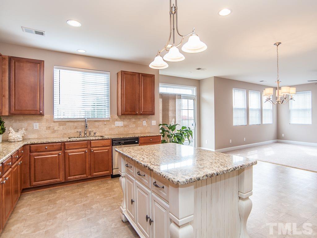 6040 Ricker Road Raleigh, NC 27610 - Photo 5 of 25 a kitchen with granite countertop a sink and white cabinets