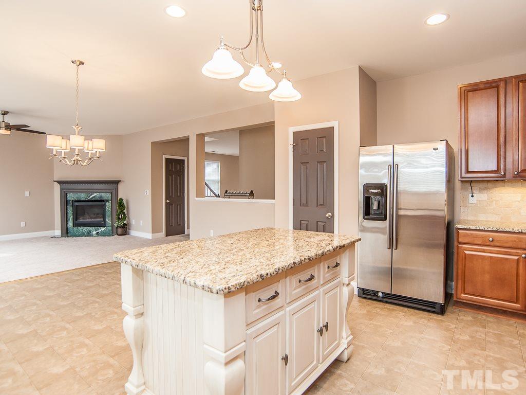 6040 Ricker Road Raleigh, NC 27610 - Photo 7 of 25 a kitchen with stainless steel appliances granite countertop a sink refrigerator and stove