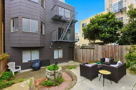 a view of a patio with chairs and a potted plant