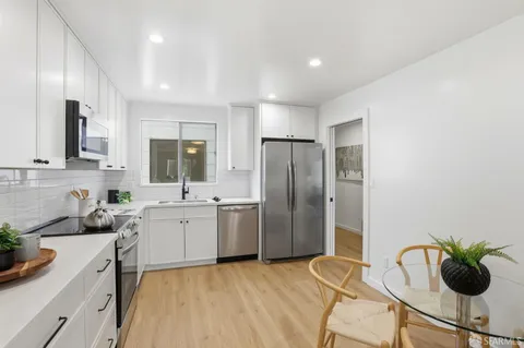 a kitchen with stainless steel appliances a sink a stove a refrigerator and cabinets
