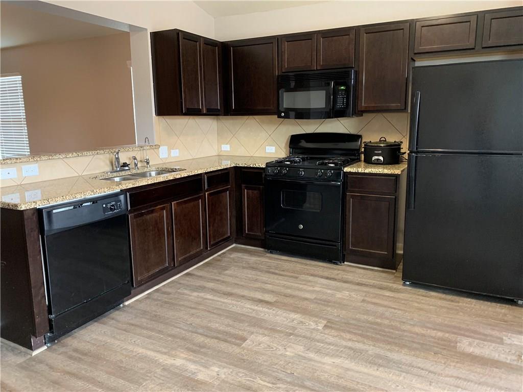351 Musgrav Kyle, TX 78640 - Photo 6 of 21 a kitchen with granite countertop a refrigerator and a stove top oven