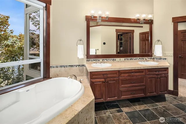 a spacious bathroom with a tub sink and mirror
