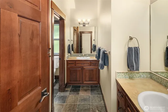 a bathroom with a granite countertop sink and a mirror