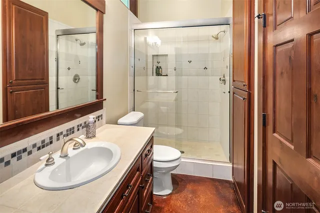 a bathroom with a sink a toilet and shower a mirror