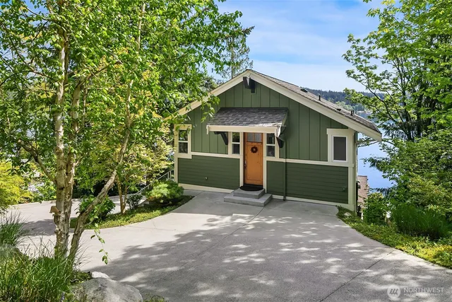 a front view of a house with a yard and trees