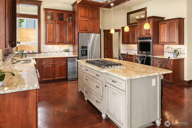 a kitchen with stainless steel appliances granite countertop a stove refrigerator and cabinets